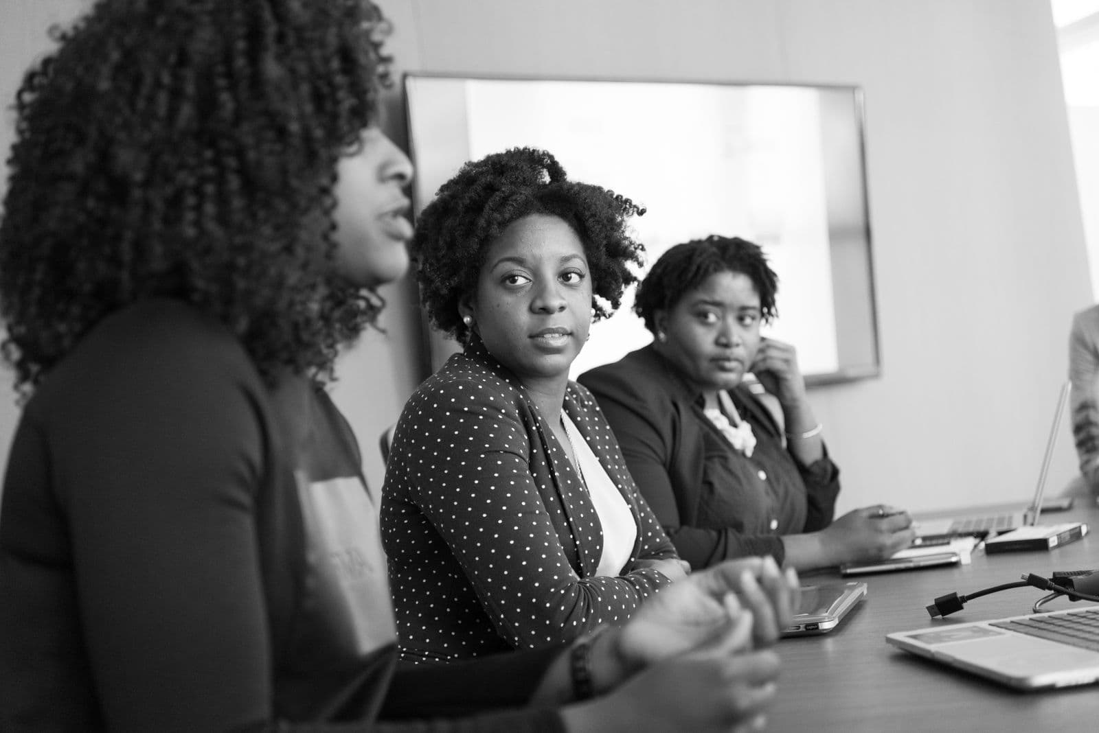 Three colleagues in a budget meeting around a conference table